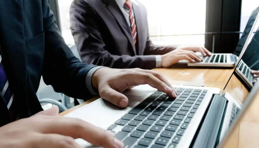 Business professionals working on laptops for network solutions.